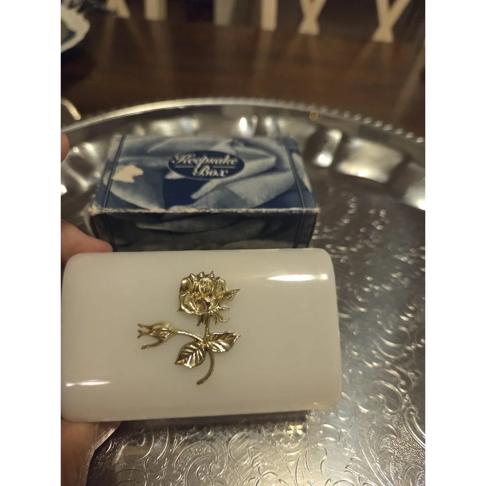 vintage white hinged trinket box features a polished finish with a delicate,...